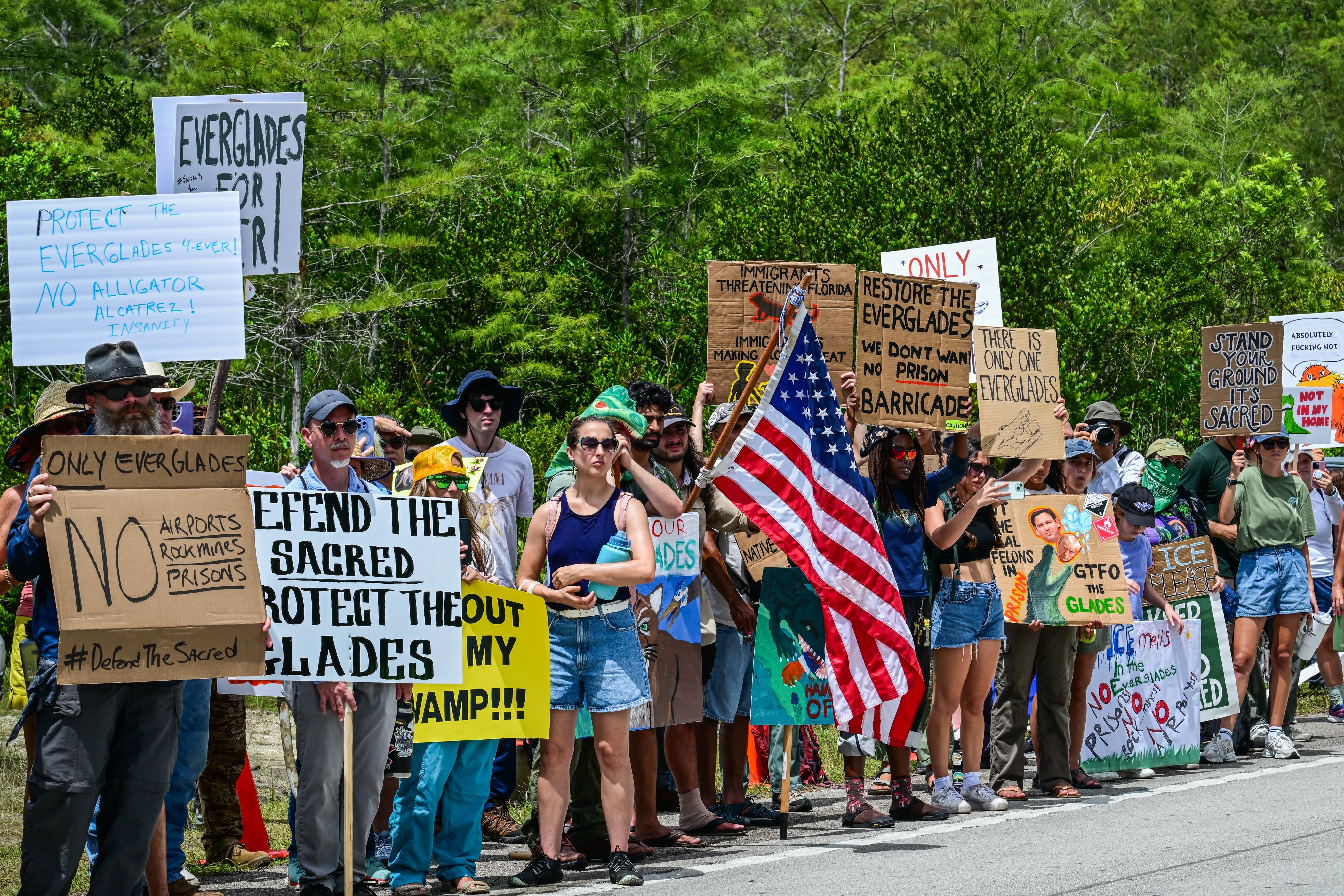 Demonstrators hold signs as they protest the construction of