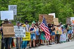 Demonstrators hold signs as they protest the construction of "Alligator Alcatraz" on Saturday.