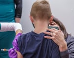 Jenni McCord, right, comforts her son as he receives a vaccination at a pediatric COVID-19 vaccine clinic held at Clackamas Town Center, Nov. 10, 2021 in Happy Valley, Ore. The clinic was offered by the Clackamas County’s Department of Public Health and offered Pfizer-BioNTech vaccines for children ages 5 through 11 years old.