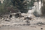 A burned motorcycle sits in the ashes of burned out residential home in the Balboa neighborhood of Spokane, Wash., on August 2, 2026.