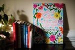 A painting of the bible verse: “God is within her, she will not fall.” There are also paintings of flowers around the text.
