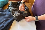 Rachael Z. Miller, founder of the Vermont-based Rozalia Project for a Clean Ocean, conducts a tape test on various clothing items to compare how much each material sheds microfibers on Thursday, April 17, 2025, in Granville, Vt.