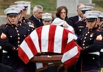 CIA officer Johnny Michael Spann, 32, was the first American killed in Afghanistan after the Sept. 11, 2001, attacks in the U.S. Spann's widow, Shannon Spann, and their 6-month-old son Jake follow Spann's casket to the grave site at Arlington National Cemetery on Dec. 10, 2001. The CIA's paramilitary force grew substantially as the agency joined the fight in Afghanistan after the 9/11 attacks.