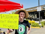 Starbucks barista Ian Meagher has worked for the company for four years. He is also a union organizer. The sign he holds references Starbucks CEO Howard Shultz's reported worth of $4 billion.