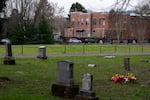 Headstones mark a block of the historic Lone Fir Cemetery as Block 14, which was once a Chinese section of the cemetery that was paved over for a county building and parking lot in the 1950s, sits railed off and without headstones in Portland, Ore., on Jan. 22, 2026.