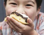 Rachel Yang’s older son, Pike Chirchi, 7, takes a bite of Upside-Down Fig Mochi Cake with Bleu Cheese Whip from her cookbook “My Rice Bowl, Korean Cooking Outside the Lines.” The sweet-savory “dessertish” rice cake can be made with dried apricots instead of Mission figs.
