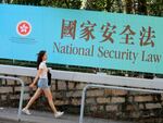 A woman walks past a promotional banner of the national security law for Hong Kong, in Hong Kong, June 30, 2020. China imposed the law that allows authorities to crack down on what they deem subversive and secessionist activities in Hong Kong.