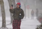 A man videos the snowfall as he walks to work in Beaverton, Ore., Feb. 13, 2025. A Guatemala native, he says he has lived in the Portland area for eight months and this is his first time seeing snow.