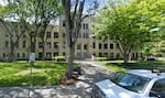 An office building stands behind some trees and grass on a sunny day in Medford, Oregon.