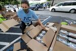 Volunteer Malka Rodrig unpacks meals at a kosher food drive-thru distribution site, Wednesday, July 29, 2020, at the Greater Miami Jewish Federation building in Miami.