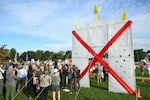 Protesters stand in Memorial Circle near a mockup of Trump's arch, which they say would be 32 times taller.
