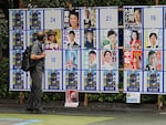 A person looks at an election poster board for Tokyo gubernatorial election Monday, July 1, 2024, in Tokyo. Tokyo elects a new governor on Sunday but residents say personal publicity stunts have overtaken serious campaigning — there are nearly nude women in suggestive poses, pets, an AI character and a man practicing his golf swing.