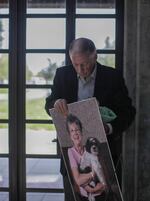 Bob Campbell carries his sister Linda's remains and portrait on his way to her gravesite.