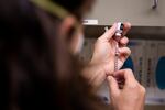 Communicable disease supervisor Jill Johnson draws out doses of the Pfizer-BioNTech COVID-19 vaccine at the Deschutes County Public Health Department in Bend, Ore., Tuesday, Jan. 12, 2021.