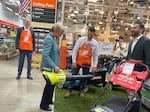 Energy Secretary Jennifer Granholm tests out an electric leaf blower at a Home Depot stop near Atlanta. In addition to promoting electric vehicles, the federal government has funded new rebates for low-income households that buy cleaner appliances or other upgrades. States are still working on the details for administering those programs.