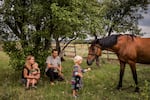 Olga and Nikolay Grinik with their son, Kirill (left), and daughter, Miroslava (right), in Avdiivka, in eastern Ukraine's Donetsk region, in July 2018. The family lived about 50 yards away from a Ukrainian front-line military position in old Avdiivka. They owned the only horse in town, Lastochka (Swallow), and made extra money giving cart rides to children in downtown Avdiivka.