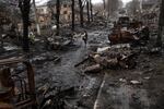 A woman walks amid destroyed Russian tanks in Bucha, in the outskirts of Kyiv, Ukraine, Sunday, April 3, 2022.