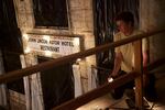 Volunteer Jonathan Swanson adjusts a light fixture in the Astor Hotel.