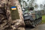 A Ukrainian soldier stands in front of a Marder infantry fighting vehicle at the German forces Bundeswehr training area in Munster, Germany, on Feb. 20, 2023.