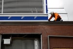 A construction worker works on the roof of Harriet Tubman Middle School.