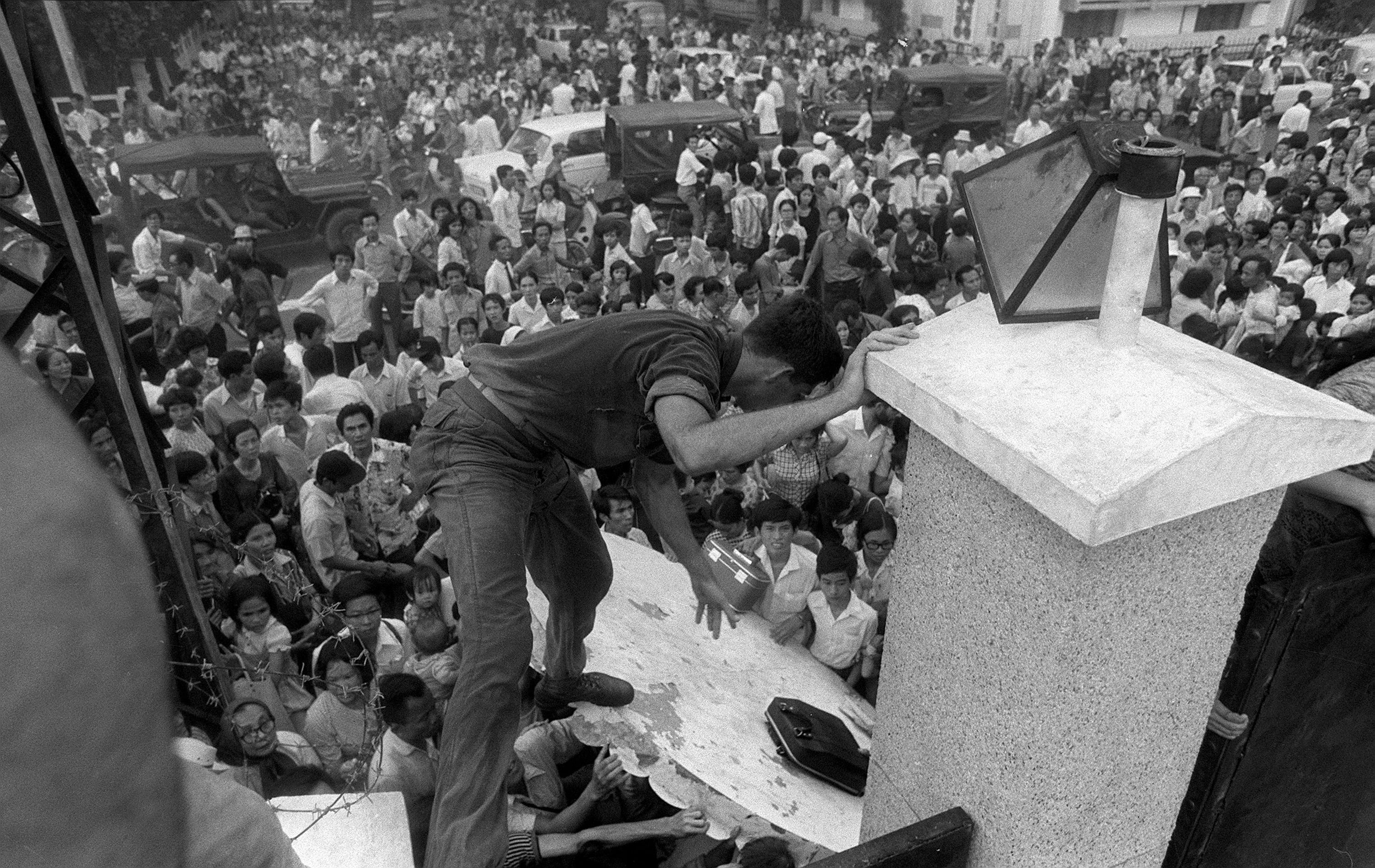Mobs of South Vietnamese civilians scale the 14-foot wall around the U.S. Embassy in Saigon on April 29, 1975, trying to reach evacuation helicopters as the last Americans departed from Vietnam.