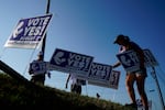 Supporters of a constitutional amendment about abortion in Kansas remove signs ahead of Tuesday's vote.