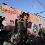 Children walk amid the rubble of a school hit during an Israeli strike before the start of a four-day truce in the battles between Israel and Hamas militants, in Rafah in the southern Gaza Strip on Friday.