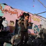 Children walk amid the rubble of a school hit during an Israeli strike before the start of a four-day truce in the battles between Israel and Hamas militants, in Rafah in the southern Gaza Strip on Friday.