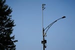 Equipment attached to the top of a light pole.