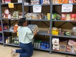 An Eastern Oregon University student volunteer restocks a campus food pantry.
