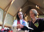 Abby Brockway (right), a member of the “Delta 5,” sings with pastor Staci Imes at Woodland Park Presbyterian Church in Seattle. Brockway and four other activists face criminal charges for blocking BNSF Railway tracks in 2014.