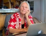 SuAnn Reddick, former volunteer historian at Chemawa Indian School, works at her laptop at her home in McMinnville, Ore., in July 2021. With the help of other researchers, Reddick published a database documenting hundreds of student deaths at Chemawa, and its predecessor, the Forest Grove Indian Training School.