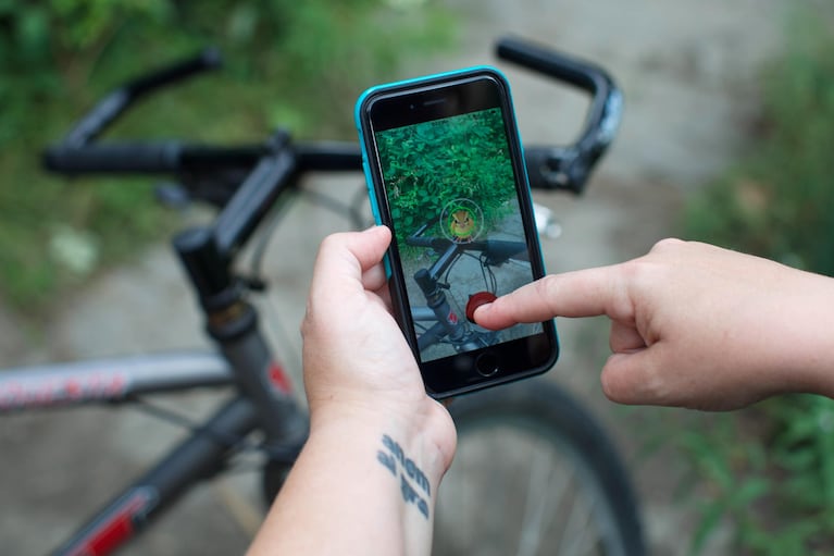 A wild Pidgey appears on bike handles while playing Pokémon Go. Augmented reality places computer-generated graphics in your phone's view of the real world.