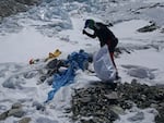 A member of a Nepal government-funded team uses a spade to remove frozen trash on Mount Everest in Nepal in 2021. In the seven decades since Mount Everest was first conquered, thousands of climbers have scaled the peak, and many have left behind more than just their footprints.