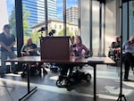 A young woman in a wheelchair approaches a podium to speak.