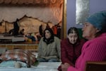 Evacuees from the mining city of Pokrovsk listen to a safety briefing at a theater turned shelter for displaced people, in Pavlohrad, Ukraine, on Oct. 19. Organizers at the facility, which offers counseling and humanitarian assistance, say that the number of people arriving has been steady with higher numbers following larger Russian attacks.