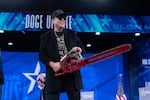Elon Musk, who oversees the Department of Government Efficiency, or DOGE, holds a chainsaw as he arrives to speak at the Conservative Political Action Conference Thursday in Oxon Hill, Md.