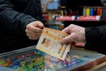 Rob, right, buys a Mega Millions ticket at Rossi's Deli in San Francisco, Thursday, Dec. 26, 2024.