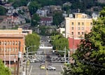 Several cars travel down Main Street, which is viewed from a short distance away from an elevated position.