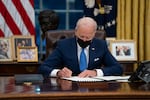 FILE - In this Feb. 2, 2021, file photo, President Joe Biden signs an executive order, in the Oval Office of the White House, in Washington.  Biden is signing an executive order to review the United States’ supply chains for large capacity batteries, pharmaceuticals, critical minerals and semiconductors.