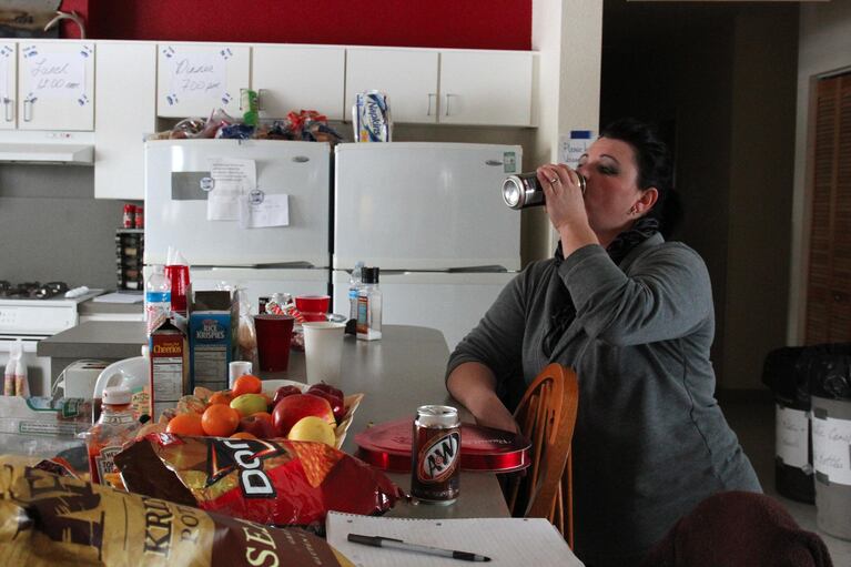 Melissa Cooper chugs an energy drink while planning the next meal. Cooper is in charge of sorting supplies, cooking, and setting up new arrivals with a place to sleep. "I'm tired. I'm getting four hours of sleep a night," she said.