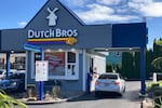 An employee of Dutch Bros Coffee in Salem, Ore., hands a drink to a customer on Wednesday, Sept. 15, 2021. After humble beginnings as a pushcart operation decades ago in an Oregon town and growing into a company with hundreds of drive-thru coffee shops in about a dozen U.S. states, Dutch Bros Coffee on Wednesday launched an initial public offering on the New York Stock Exchange.