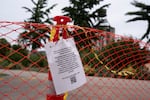 A notice hangs on a fence at The Fields Park.
