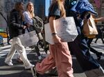 People walk along 5th Avenue in Manhattan, which is one of the nation's premier shopping streets, on Feb. 15, 2023. Consumer spending was unexpectedly strong last month. That's good for the economy – but not so good for inflation prospects.