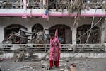 A woman salvages usable materials from her house deluged in sludge following flash floods at Devighat in Nepal's Nuwakot district.