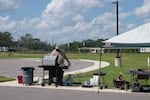 A volunteer works the grill in front of Creekside Church. Members of the church worked together throughout the day to provide food and drinks for anyone who might need it.