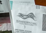 An image of a mail in ballot envelope and voters pamphlet