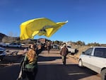 A mourner waves a "Don't Tread On Me" flag behind a procession of horseback riders at LaVoy Finicum's funeral.