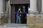 A pedestrian walks into United Bank as ribbons in honor of Sarah Beckstrom adorn the door on Main Street in Webster Springs, W.Va., on Wednesday.
