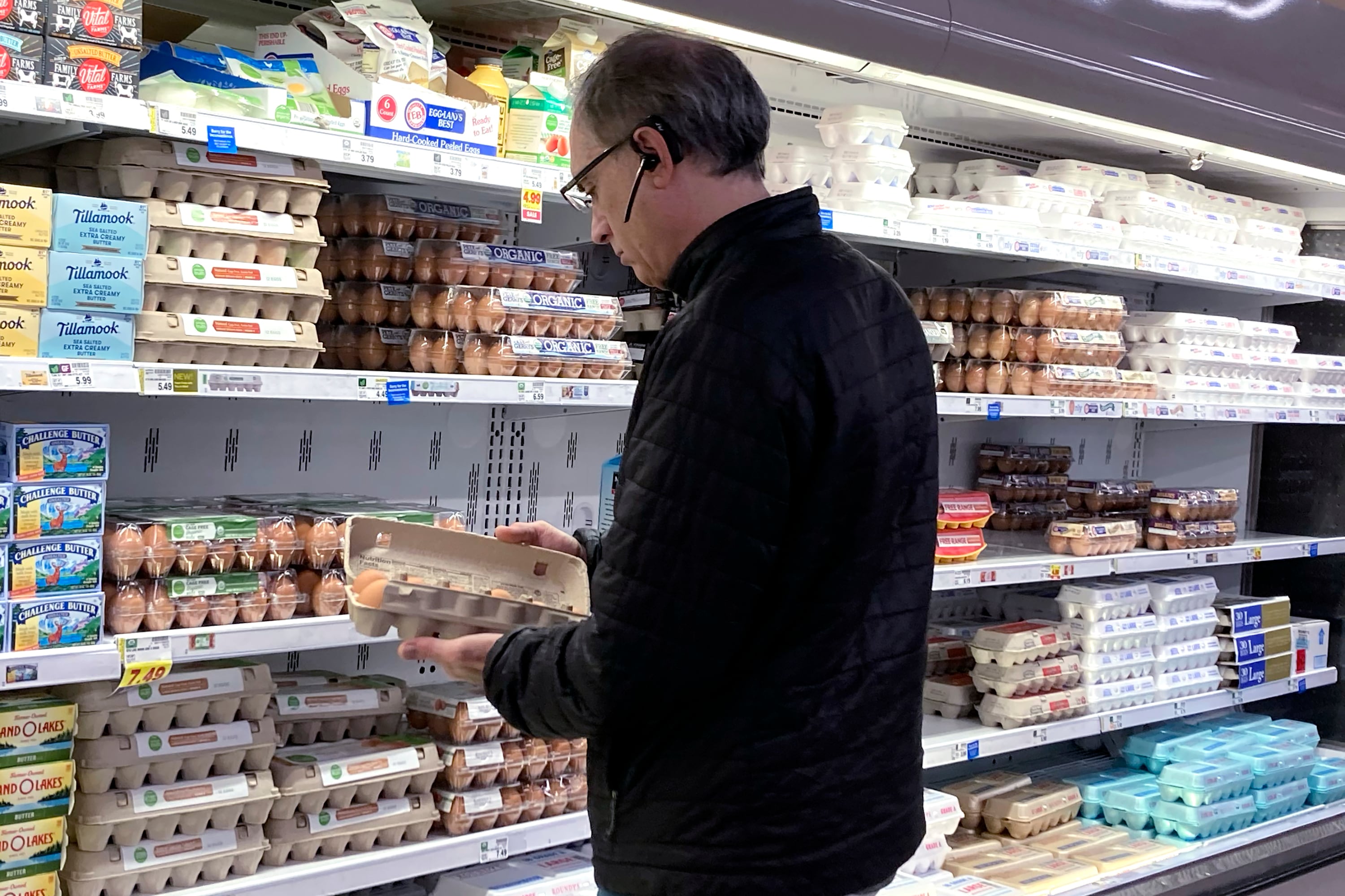 FILE - A shopper checks eggs before he purchases at a grocery store in Glenview, Ill., Tuesday, Jan. 10, 2023.